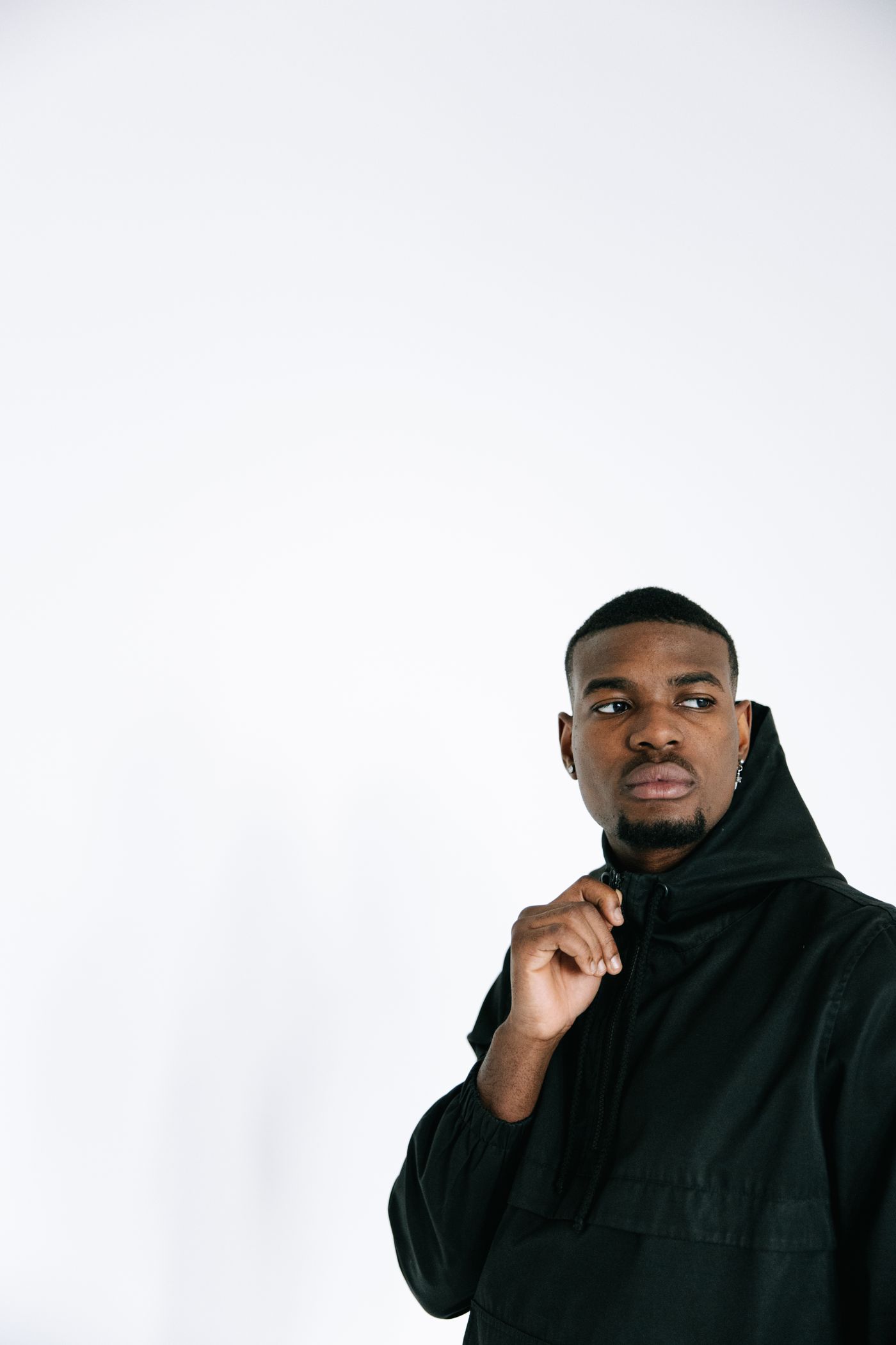 Monoloom Shell Anorak, a dark pullover anorak against a white studio wall